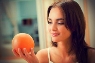 Beautiful brunette looking at Grapefruit