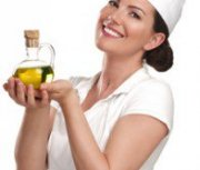 Female Chef in White Holding a Bottle of Olive Oil