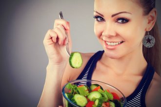 Girl eating fresh vegetables salad