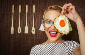 Woman Smiling and Holding a Fried Egg